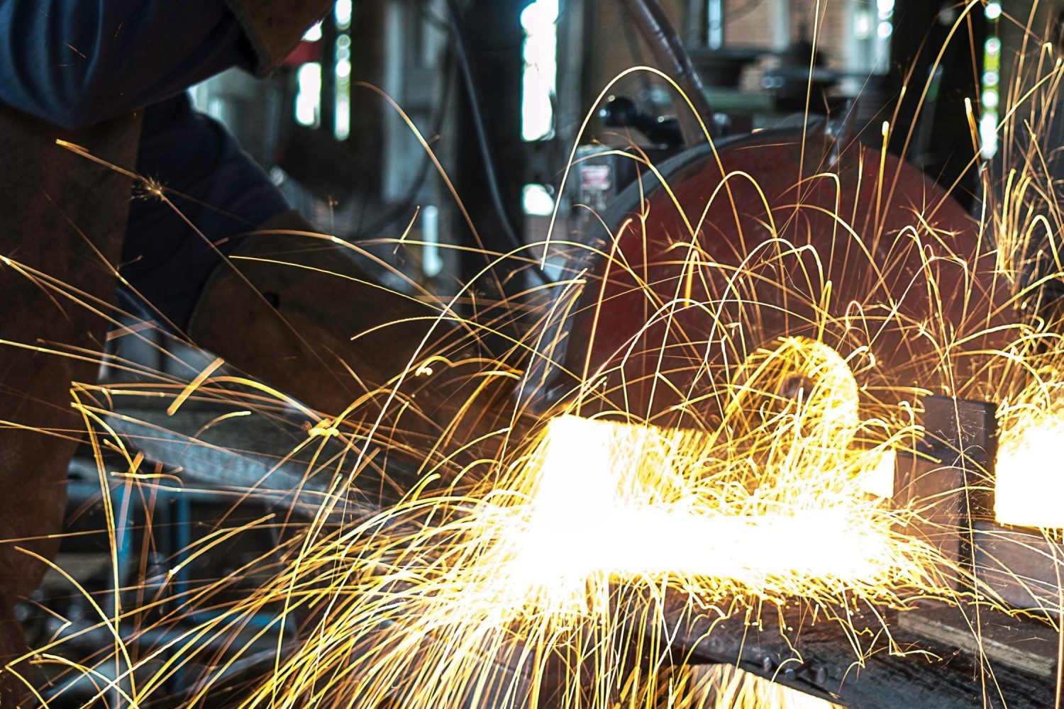 Vibrant sparks fly during welding in a busy workshop, showcasing intense craftsmanship.